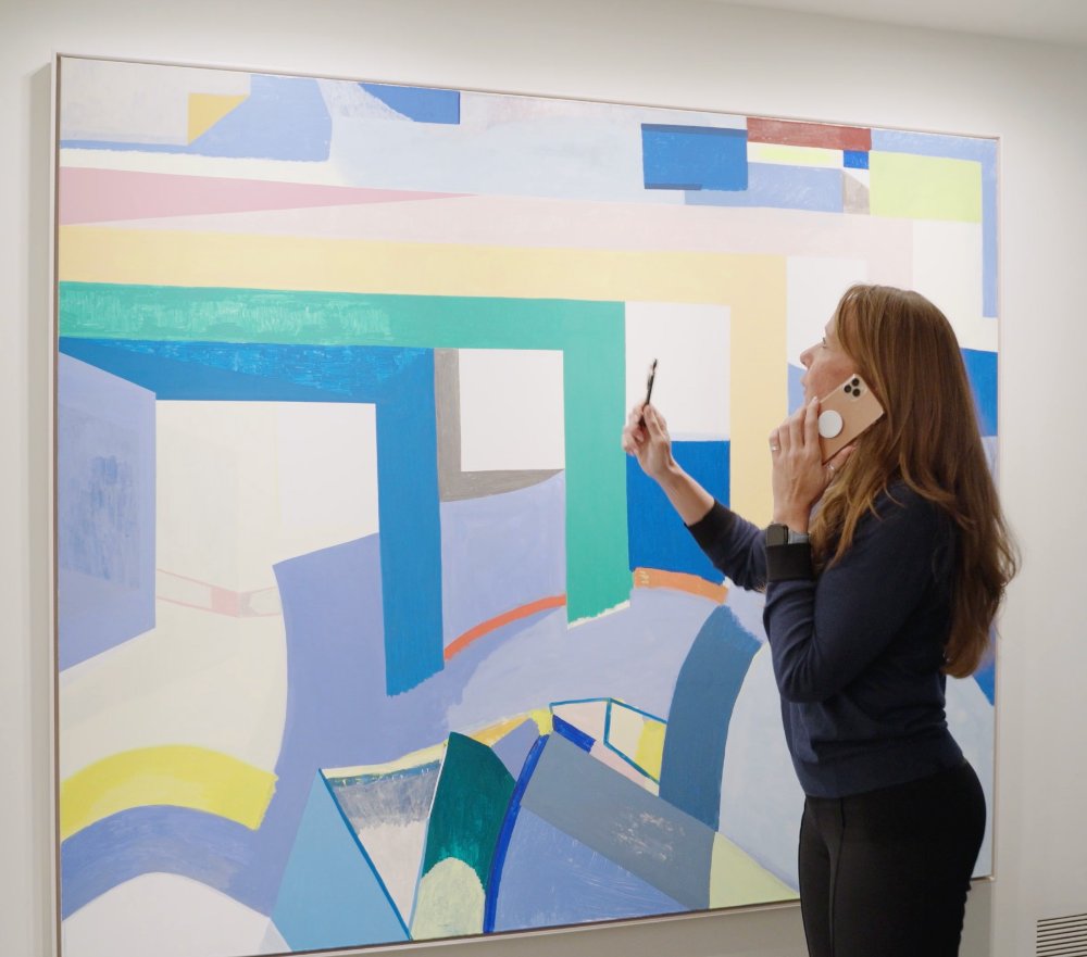 Sharikay Sloboda inspecting a painting, Carnelian Collective.